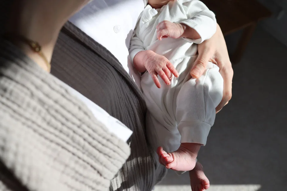 A mother holding her newborn close in natural light