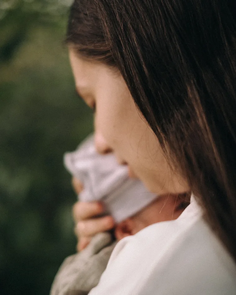A woman holding her newborn close