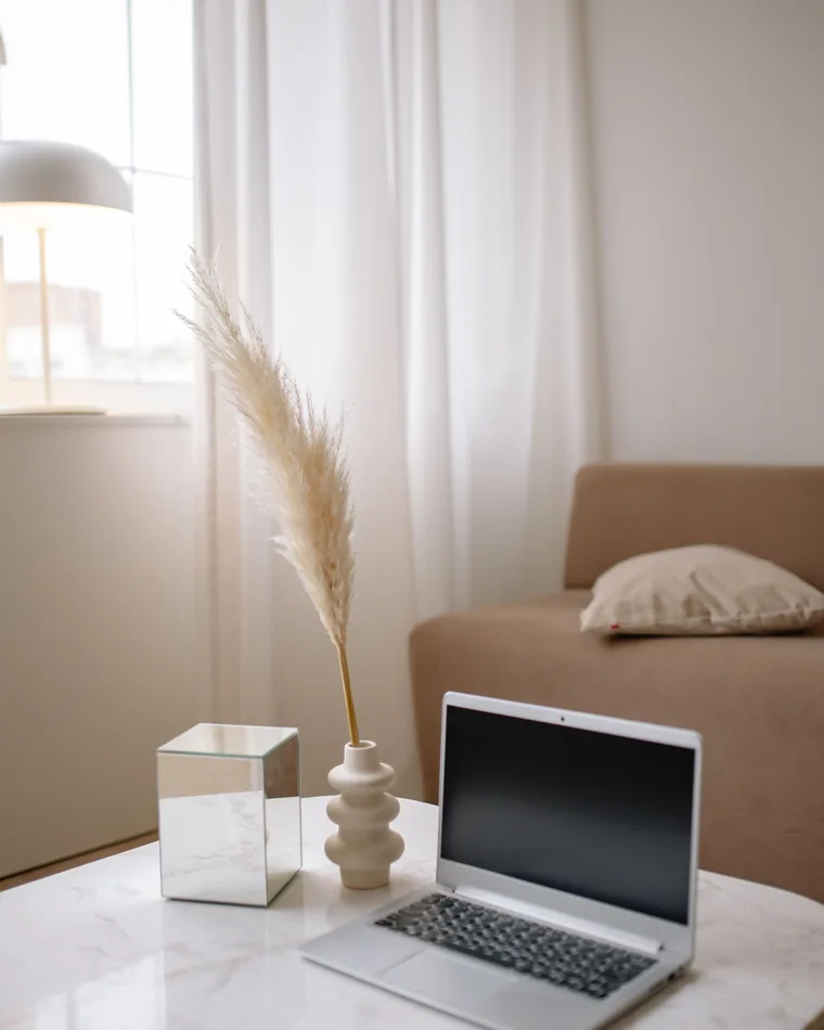 A laptop on a table in a bright room, ready for a telehealth visit